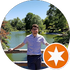 Person standing by a lake with trees in the background